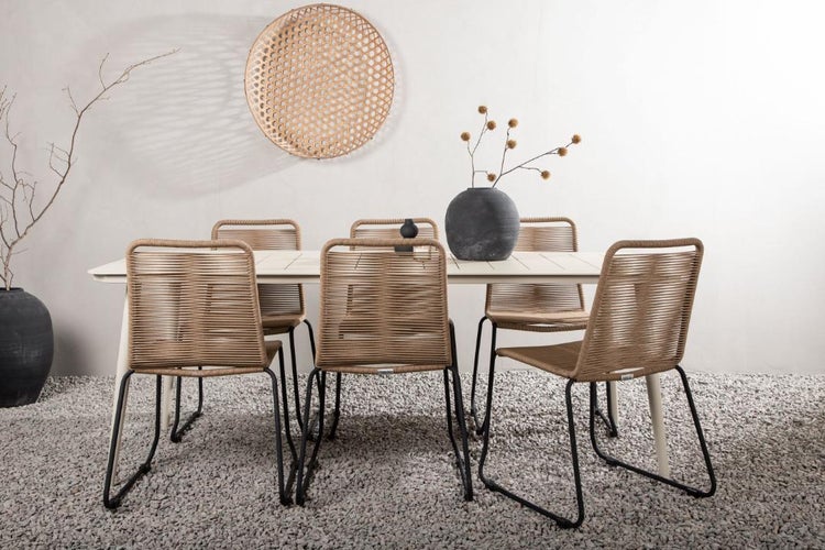 Gartenszene mit Esstisch und Stühlen aus Rattan, dekoriert mit einer Vase