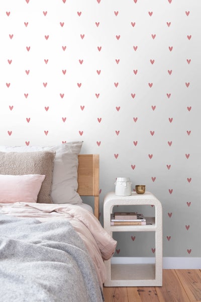 Schlafzimmer mit Wandtapete mit Herzmuster, Bett und Nachttisch