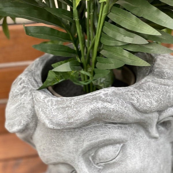 Pflanzgefäß in Kopf Form aus Steinoptik mit Kunstpflanze