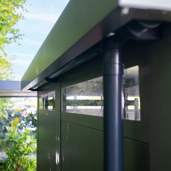Detailaufnahme eines Gartenhauses mit Fenstern und Regenrinne