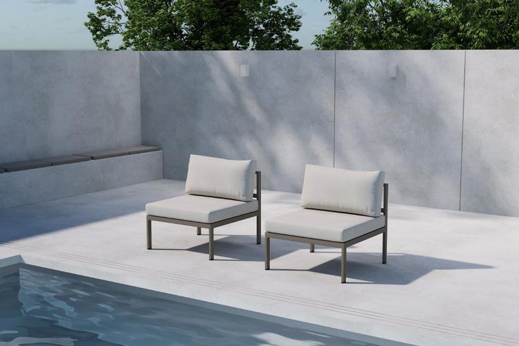 Zwei Gartenstühle aus Metall mit Kissen stehen im Freien neben einem Pool.