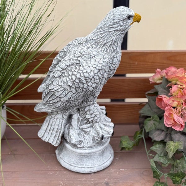Gartenfigur Adler aus Steinguss auf einem Sockel, detailgetreue Federstruktur, dekorative Steinfigur für Garten und Terrasse.