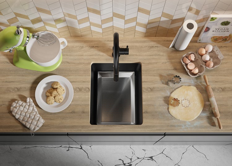 Küchenszene mit Spüle, Armatur, Küchenmaschine, Backzutaten und Kochbuch.