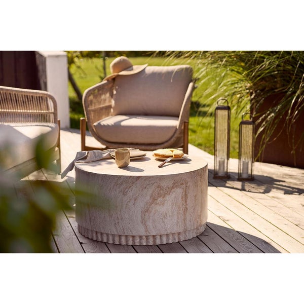 Terrassenszene mit rundem Tisch, Geschirr und Sitzgelegenheiten für den Aussenbereich