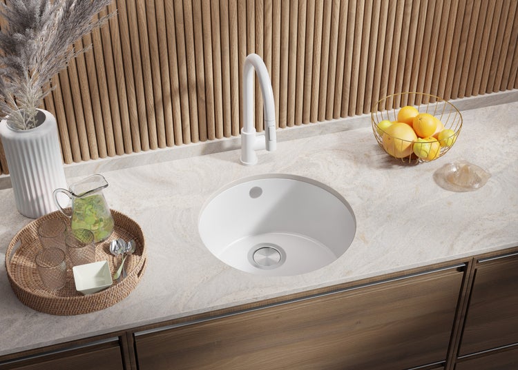 Küchenszene mit rundem Spülbecken, Armatur und Accessoires auf einer Arbeitsplatte