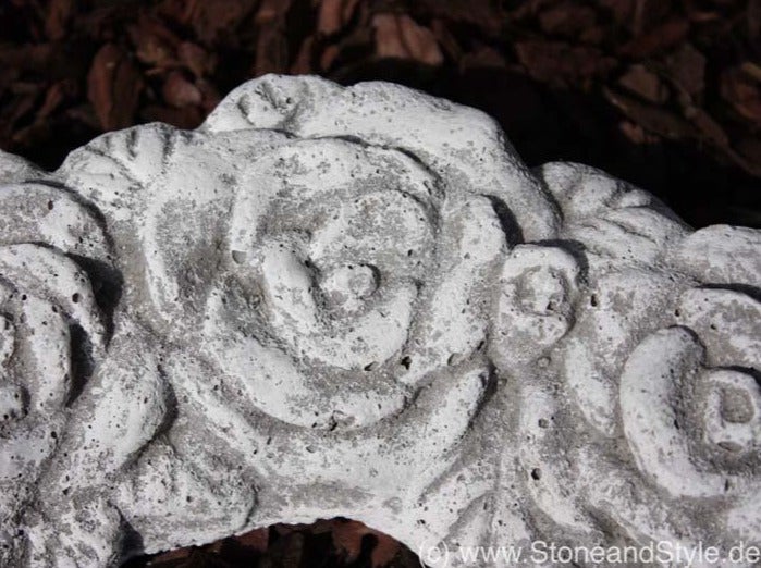 Gartendekoration aus Stein in Rosenform mit detailliertem Relief.