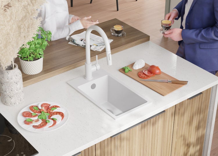 Küchenspüle mit Armatur in einer hellen Küche mit Lebensmitteln zubereitet