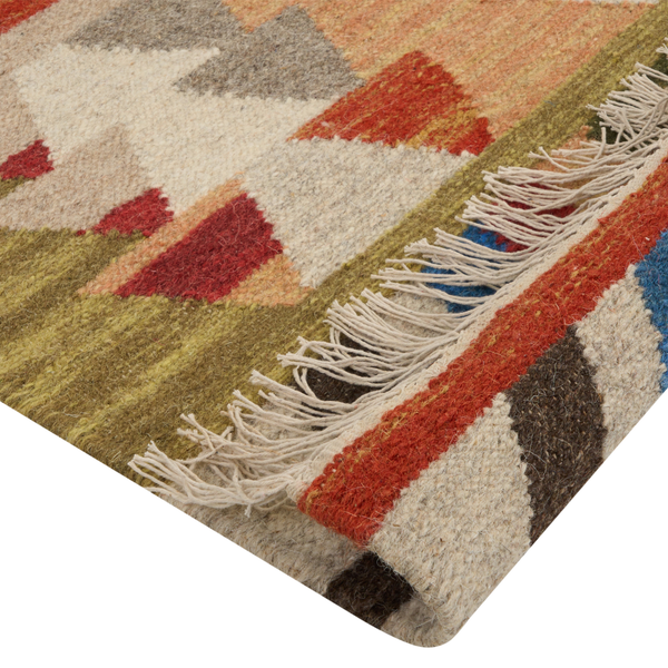 Nahaufnahme eines handgewebten Kilim-Teppichs mit bunten geometrischen Dreiecksmustern und Fransen.