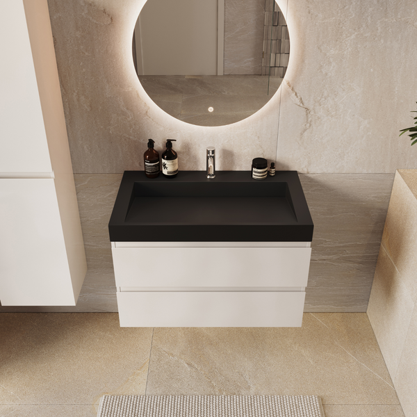 Modernes Badezimmer mit Waschtischunterschrank, aufgesetztem Waschbecken, rundem LED Spiegel und hohem Badschrank vor steinoptischen Fliesen.