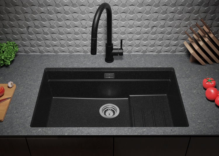 Schwarzes Spülbecken mit Wasserhahn in einer Küchenszene.
