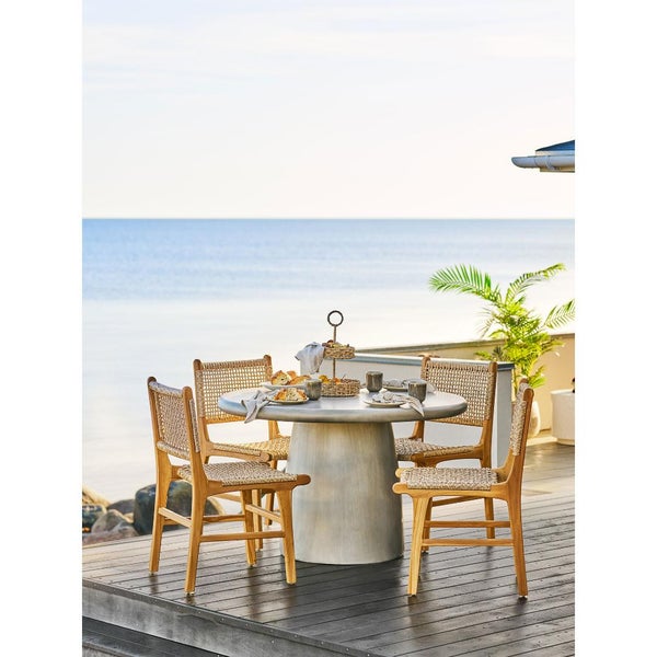 Esstischgruppe mit vier Stühlen auf einer Terrasse mit Meerblick