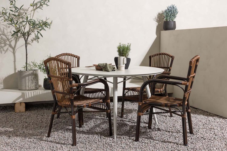 Gartenszene mit rundem Tisch und Rattanstühlen