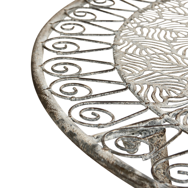 Detailansicht eines Gartentisches aus Metall mit dekorativem Muster