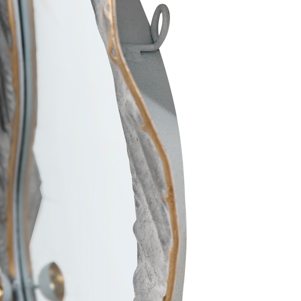 Detailansicht eines runden Wandspiegels mit grauem Rahmen und goldfarbenen Akzenten