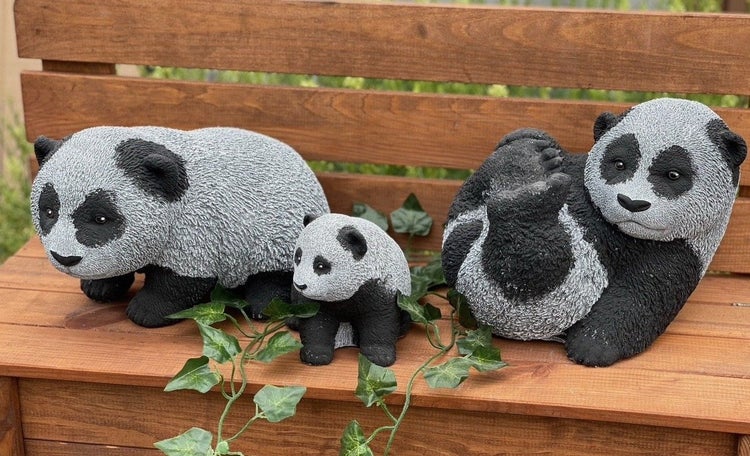 Drei Panda Gartenfiguren aus Kunststein auf einer Holzbank mit künstlicher Efeu Dekoration.