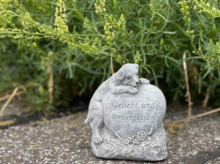 Grabschmuck für Haustiere als Steinfigur in Herzform mit Hundefigur und der Inschrift Geliebt und unvergessen als Gedenkstein für den Garten