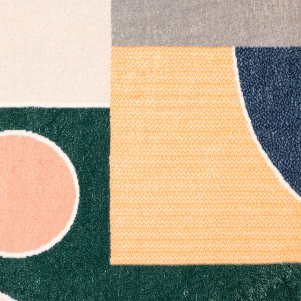 Detailansicht eines Teppichs mit geometrischem Muster aus Kreisen und Rechtecken in verschiedenen Farben.