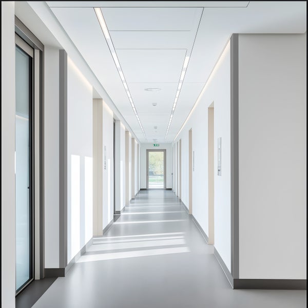 Heller Flur mit linearen Leuchten und Türen
