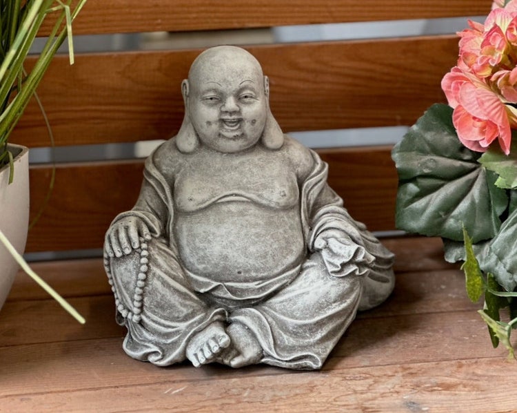Sitzende Buddha-Figur in Steinoptik für den Garten, lachend und im Schneidersitz mit einer Gebetskette.