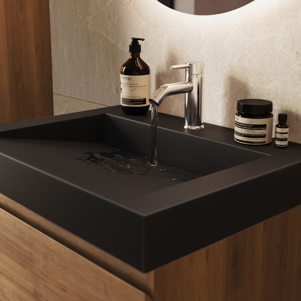 Modernes Badezimmer mit Waschtisch in Holzoptik und schwarzem Waschbecken, dazu eine glänzende Armatur mit fließendem Wasser.
