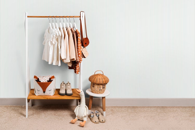 Kinderzimmer mit Kleiderständer, Kleidung, Spielzeug und Accessoires.