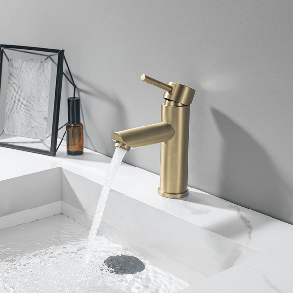 Moderne Einhebel Waschtischarmatur in matter Oberfläche mit fließendem Wasser über einem weißen Marmorwaschbecken im Badezimmer.