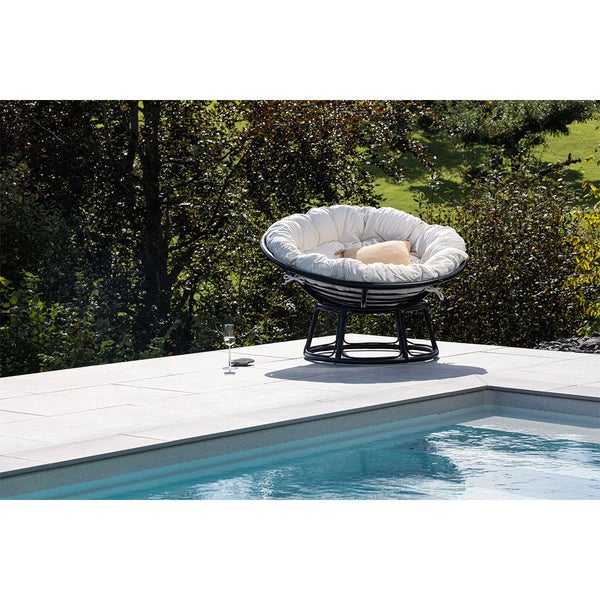 Papasan Sessel mit Kissen neben Pool im Garten