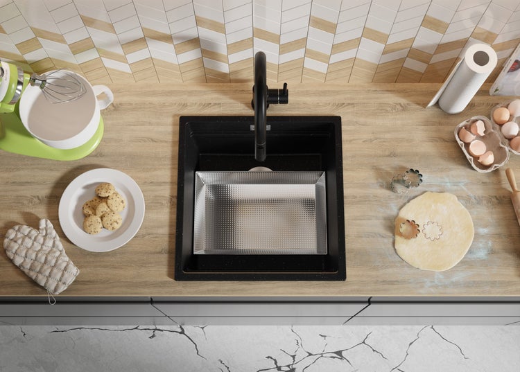 Küchenszene mit Spüle, Armatur, Teig, Ausstechern und Küchengeräten.