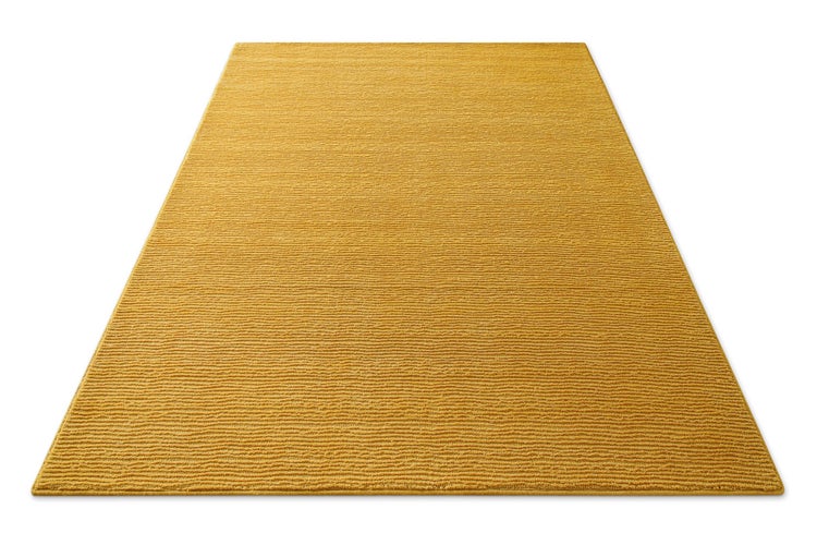 Rechteckiger Teppich in Senfgelb mit gerippter Struktur.