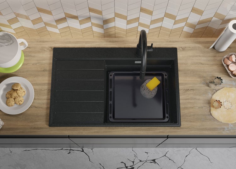 Küchenszene mit Spüle, Armatur und Backutensilien auf einer Arbeitsplatte.