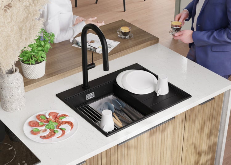 Küchenszene mit Spüle, Armatur, Geschirr und Speisen auf einer Küchentheke.