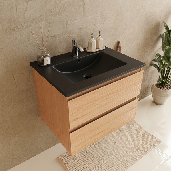 Moderner Waschtisch aus Holz mit zwei Schubladen, schwarzem Waschbecken und Armatur in einem hellen Badezimmer mit Pflanze.