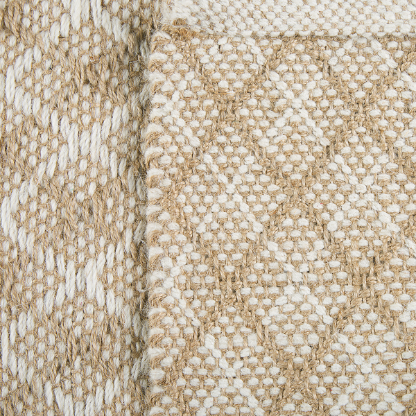 Detailansicht eines gewebten Teppichs aus Jute und Wolle mit grober Oberflächenstruktur.