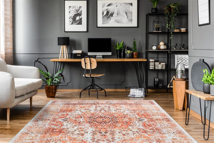 Helles, organisiertes Homeoffice mit orientalisch gemustertem Teppich auf Holzboden, Holzschreibtisch, Zimmerpflanzen und modernen Wandelementen.