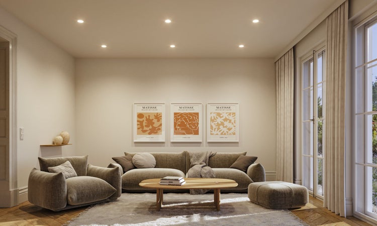Modernes, gemütliches Wohnzimmer mit Sofa, Sessel, Couchtisch und drei Matisse Wandbildern in einem hellen, einladenden Ambiente.