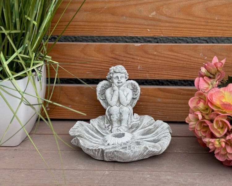 Dekorative Gartenfigur eines Engels auf einer blütenförmigen Schale aus Stein für den Außenbereich