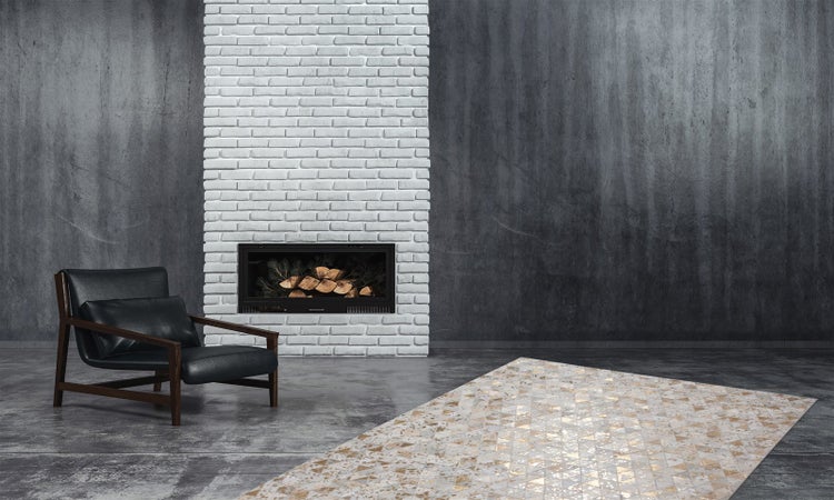 Moderner Wohnbereich mit weißem Backsteinkamin, schwarzem Leder-Lounge-Sessel und geometrisch gemustertem Teppich vor dunkler Betonwand.
