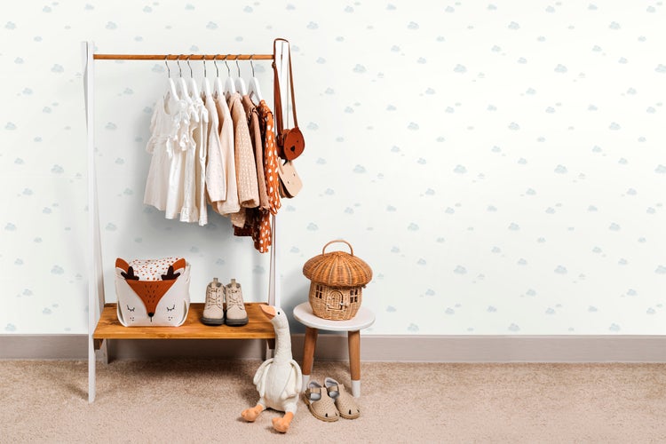 Kinderzimmer mit Kleiderständer, Kleidung, Spielzeug und Accessoires.