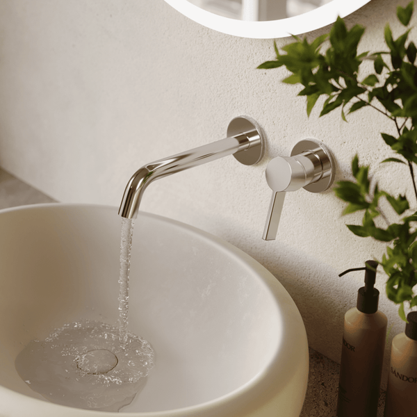 Wandmontierte Waschtischarmatur mit Einhebelmischer über einem runden Waschbecken mit fließendem Wasser.