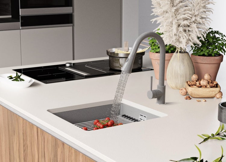Küchenspüle mit Armatur und Gemüse unter fließendem Wasser in einer modernen Küche