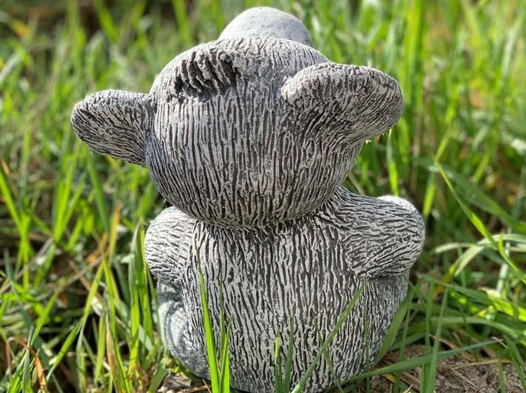 Gartenfigur Teddybär aus Steinzeug in einer Grünfläche