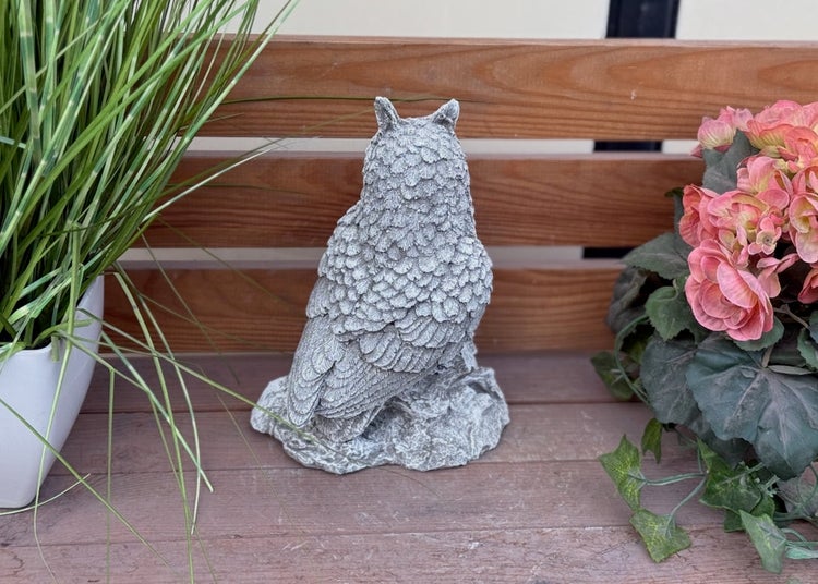 Gartenfigur Eule aus Steinguss, Rückansicht mit detailreichen Federn, dekoriert auf einer Holzbank mit Pflanzen.