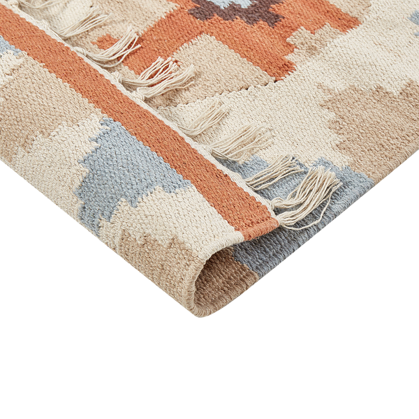 Thuja-Säulenbaum im Gartenbeet mit Blumen