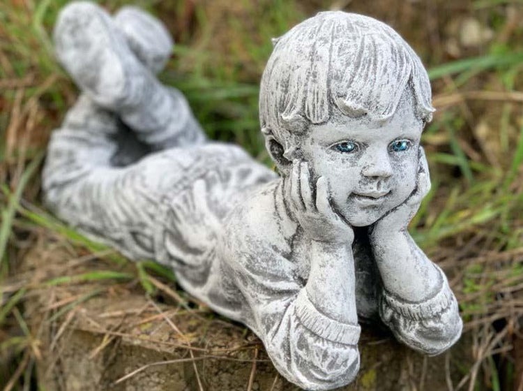 Gartenfigur in Form eines liegenden Jungen aus wetterfestem Steinguss zur Dekoration im Außenbereich