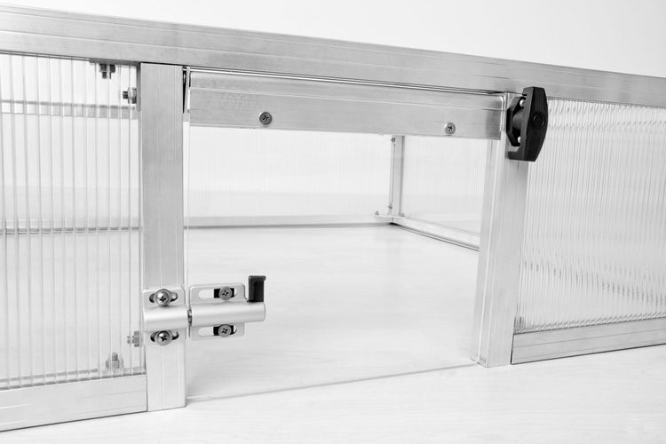 Schiebetür-Mechanismus eines Frühbeets aus Aluminium und Polycarbonat mit Verriegelung.