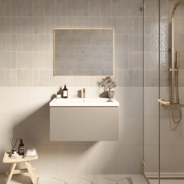 Modernes Badezimmer mit hängendem Waschbeckenunterschrank, weißem Waschbecken, beleuchtetem Spiegel und goldfarbenen Armaturen.