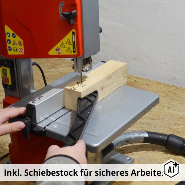 Bandsäge beim Zusägen eines Holzstücks mit Hilfe eines Schiebestocks für sicheres Arbeiten.