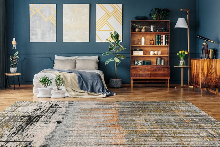 Moderner Teppich mit abstraktem Muster in einem Schlafzimmer mit Bett, Holzmöbeln und Zimmerpflanzen auf Holzboden.