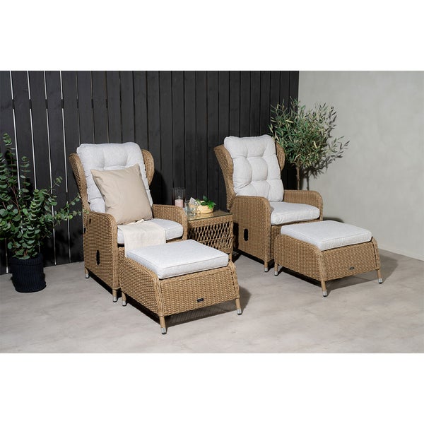 Zwei Korbsessel mit Fußhocker und Beistelltisch bilden eine Sitzgruppe für den Garten.