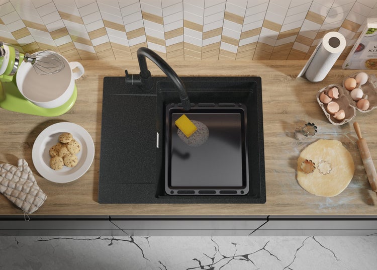 Küchenszene mit Spüle, Armatur, Geschirr, Zutaten und Küchenutensilien auf einer Arbeitsplatte.